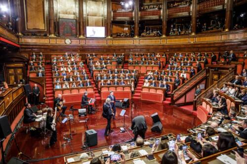 Concerto all'interno dell'aula del Senato della Repubblica per il 75esimo anniversario.L'immagine inquadra senatori e musicisti.
